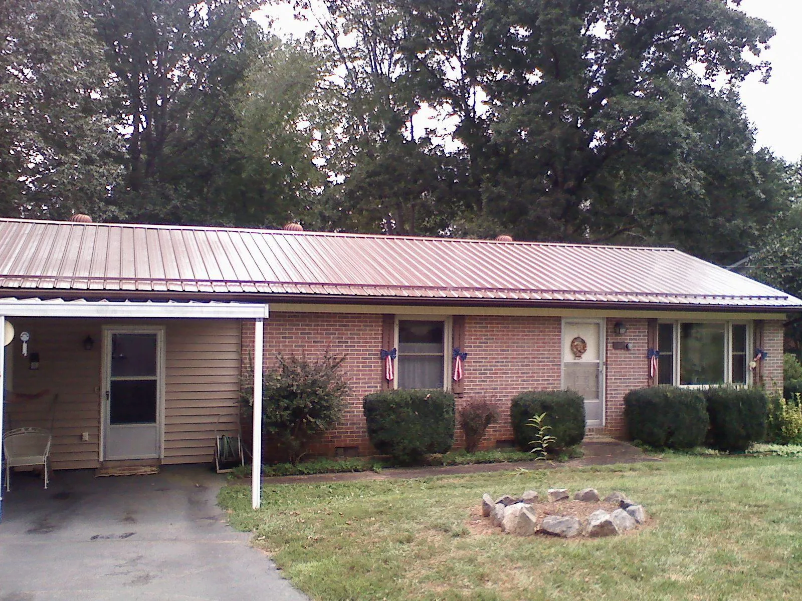 Bronze metal roof and carport on a brick ranch home — Roof Repair work by our crew in Fruitland