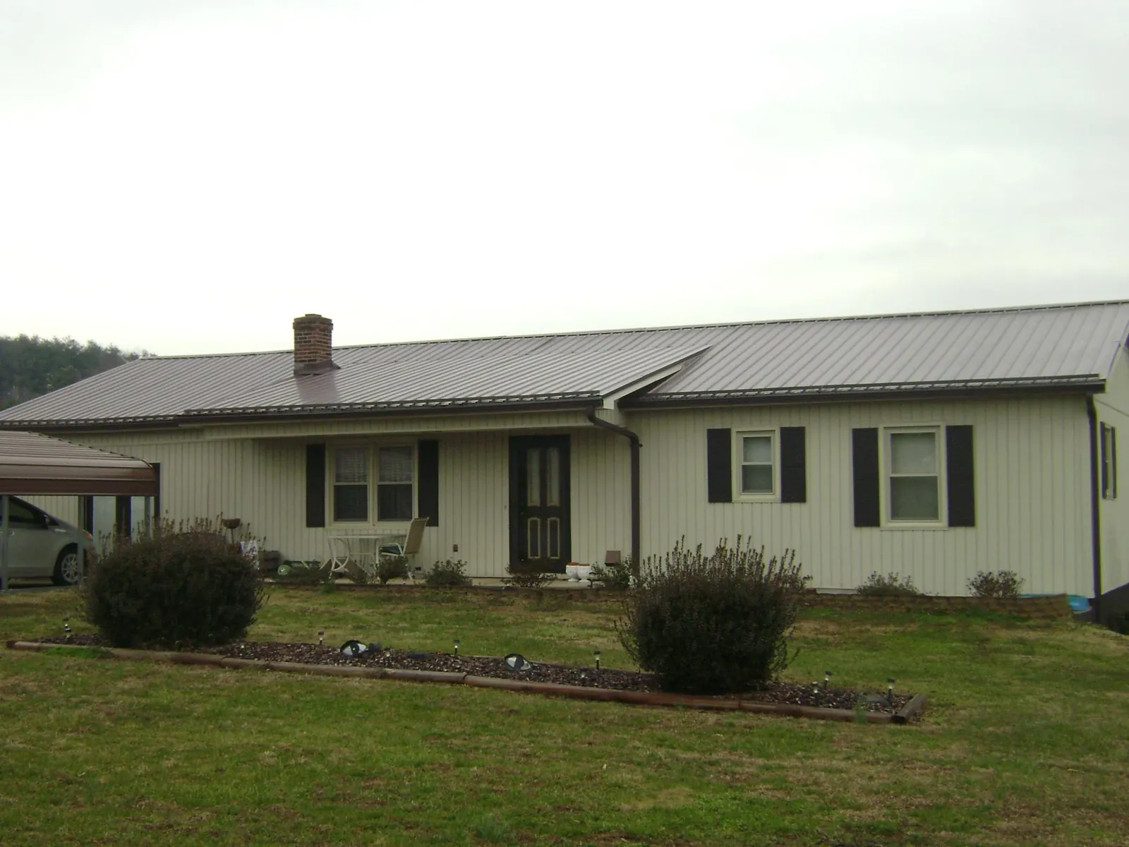 Brown metal roof on a cream sided ranch home with a brick chimney in Fruitland